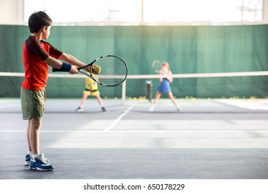 Niño concentrado lanzando pelota de tenis