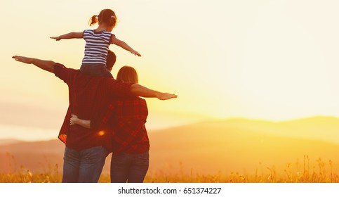 幸せな家族: 日没の自然に母父と子娘