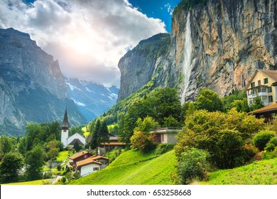 Pueblo alpino turístico asombroso con la iglesia famosa y la cascada de Staubbach, Lauterbrunnen, Suiza, Europa