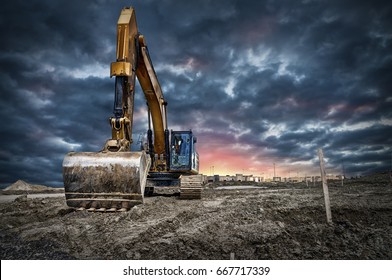 建設現場のショベル機械、背景に夕日。