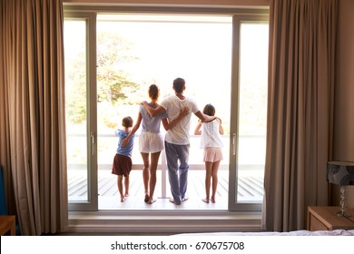Rear View Of Family On Balcony Looking Out On New Day
