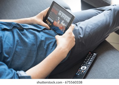 Người đàn ông đang xem phim truyền hình trực tuyến bằng máy tính bảng kỹ thuật số