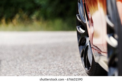 Detalle de las ruedas de un coche deportivo rojo intenso con frenos deportivos