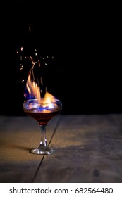 Glass of flaming cocktail with sparks of buring cinnamon (flaming lamborghini)