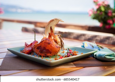 Kepiting laut goreng disajikan dengan selada, roti dan saus cabai di pantai