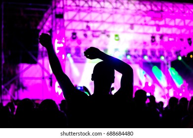 ファンは、ハムレット メタル バンド Rammstein のコンサート中にホールのファン ゾーンでコンサートを楽しんでいます。手を上げた大勢の人々のシルエット。セレクティブ フォーカス
