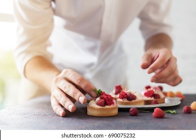 Preparación de tortas con frambuesas en una mesa