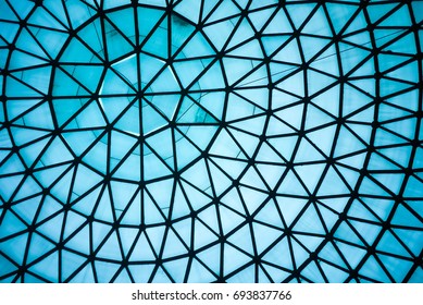 Atap Kaca Biru Lengkung atau Plafon Kubah dengan Struktur Geometris Baja Hitam dalam Gaya Arsitektur Modern dan Kontemporer sebagai latar belakang atau pola arsitektur dan industri abstrak