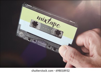 hand holding a 80s tape audio cassette labeled mixtape