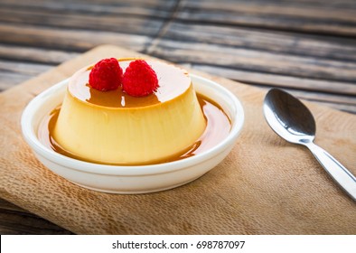 Puddingkaramelvla met frambozen op houten achtergrond