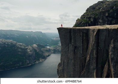 山の頂上に立ちながら、カメラを持った自然写真家の観光客が撮影します。美しい自然ノルウェー Preikestolen または Prekestolen。