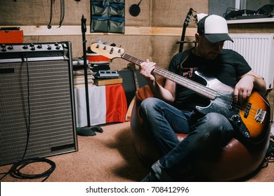 音楽スタジオでギターを弾くベースギタリスト。コンサート前のガレージでのバンドの繰り返し、音楽的背景