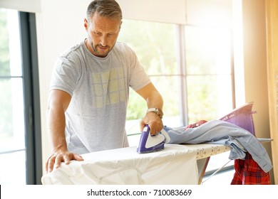 Man at home ironing clothes