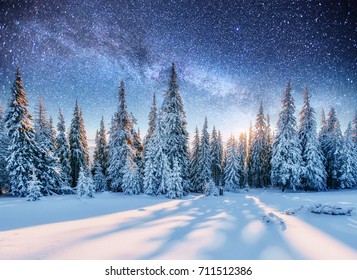 Perjalanan bintang susu di atas hutan pinus. Pemandangan misterius pegunungan megah di musim dingin.