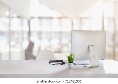 Elegante espacio de trabajo con computadora de escritorio, suministros de oficina, plantas de interior y libros en la oficina. concepto de trabajo de escritorio.