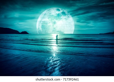 Supermond. Bunter Himmel mit hellem Vollmond über Seelandschaft und Schattenbild der Frau, die im Meer steht. Serenity Naturhintergrund, im Freien bei Dämmerung. Der Mond mit meiner eigenen Kamera aufgenommen.