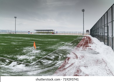 Campo de fútbol de césped artificial cubierto de nieve