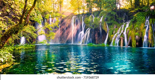 Das letzte Sonnenlicht beleuchtet den Wasserfall mit reinem Wasser im Nationalpark Plitvice. Buntes Frühlingspanorama des grünen Waldes mit blauem See. Toller Blick auf die Landschaft von Kroatien, Europa.