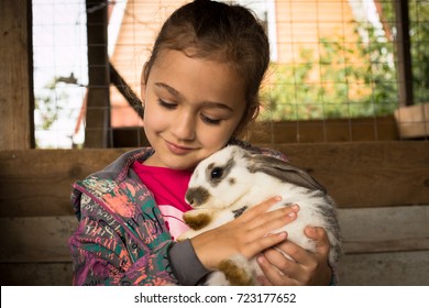 Kanin. Sød lille pige holder i sin omfavnelse Sød kanin.