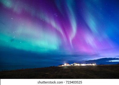 kleurrijk noorderlicht in een landschap van IJsland met cottage berg en zee