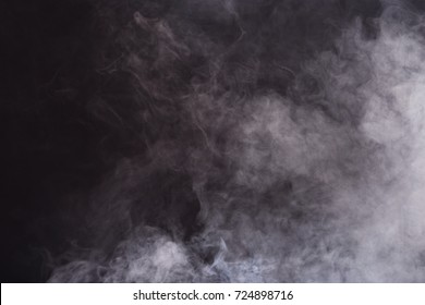 黒の背景に白い煙と霧の密なふわふわのパフ、抽象的な煙の雲、すべての動きがぼやけ、焦点が合っていない意図、および高低露出コントラスト、テキストロゴ用のコピースペース