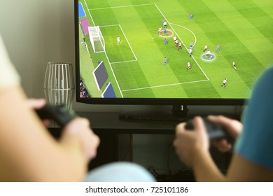 Dva tipa igraju zamišljeni nogomet za više igrača ili nogometnu video igru ​​s konzolom i televizorom. Muška večer, zabava i koncept vikenda.