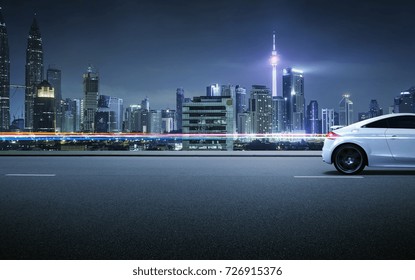 Auto sportiva sul ciglio della strada con scena notturna e sullo sfondo una città moderna.