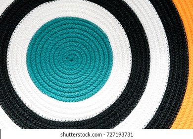 Close up circular pattern of colorful woven fabric rug.