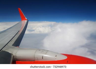 El ala del avión por encima de la nube blanca en el cielo azul, 10.000 pies sobre el suelo