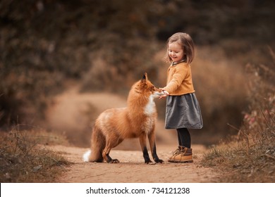 một cô bé với một con cáo trong rừng mùa thu