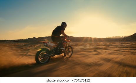 Shot of the Professional Motocross Driver Riding on His FMX Motorcycle on the Extreme Off-Road Terrain Track. Blur motion.