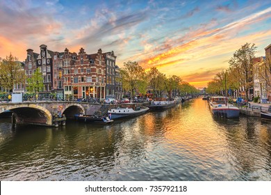 De skyline van de zonsondergangstad van Amsterdam aan de waterkant van het kanaal, Amsterdam, Nederland