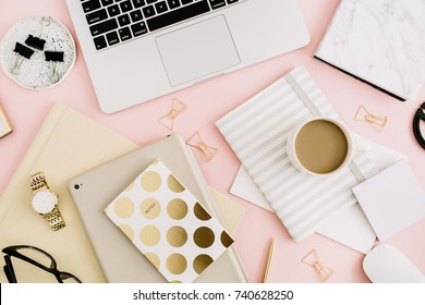 Không gian làm việc bàn văn phòng hiện đại với máy tính xách tay, sổ ghi chép và văn phòng phẩm trên nền màu hồng nhạt. Nhìn từ trên xuống. Tiêu đề không gian làm việc phong cách sống phẳng.