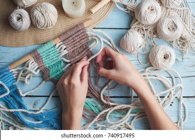 Hobby maglia macramè vista dall'alto della mano e del filo su una tavola di legno
