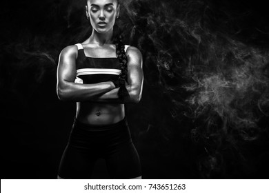 スポーティな美しいアフリカ系アメリカ人モデル、スポーツウェアを着た女性は、健康を維持するために黒い背景でフィットネスエクササイズを行います