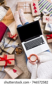 Vianočné online nakupovanie pohľad zhora. Žena robí poriadok na notebooku s kreditnou kartou, kopíruje priestor na obrazovke. Žena sediaca medzi darčekovými krabičkami a balíčkami. Výpredaj zimnej dovolenky