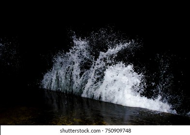 Spritzende Welle auf dem Schwarzen Meer in der Nacht.