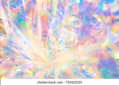 Abstract radiant festive merry holiday backdrop texture image of holographic iridescent metallic foil ribbon decoration with warm bright glow and sparkling crystal ice reflections and bokeh light