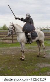 騎士が剣を手に白馬に乗っています。鎧の男。チェーンメールのモデル。中世の鎧