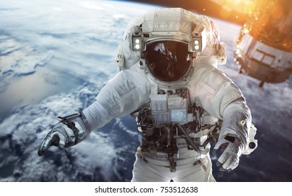 地球軌道で船外活動をする勇敢な宇宙飛行士。宇宙の人々。NASA から提供されたこの画像の要素