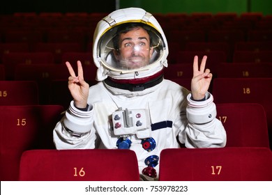 Bir sinema astronotu patlamış mısır yerken ve filmin tadını çıkarırken bir film izliyor. Kavram: sinema ve uzay filmleri, diğer dünyanın filmi, gerçeküstü durumlar.