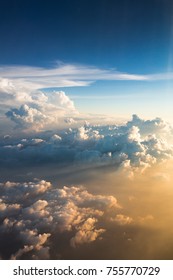 Zonsondergang boven wolken verlicht door de stralen van de zon vanuit het vliegtuigraam. Zonsondergang met een hoogte van 11.000 km. Uitzicht op de prachtige cumuluswolken bij zonsondergang vanuit een vliegtuigraam, ware kleuren