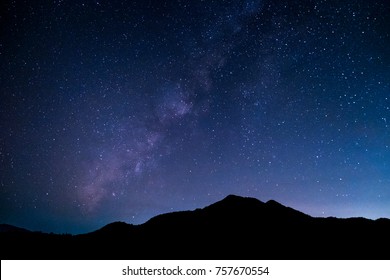 Montañas, la Vía Láctea y estrellas en el hermoso cielo nocturno.