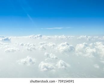 晴れた日の海抜 10,000 フィートの青い空と白い雲、飛行機の窓からの視点。