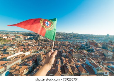 hand met Portugese vlag op luchtfoto van het historische centrum van Porto in Portugal vanaf de Clerigos-toren, een van de bezienswaardigheden en het icoon van Porto. Stedelijk stadsbeeld met blauwe lucht
