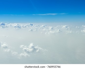 晴れた日の海抜 10,000 フィートの青い空と白い雲、飛行機の窓からの視点。