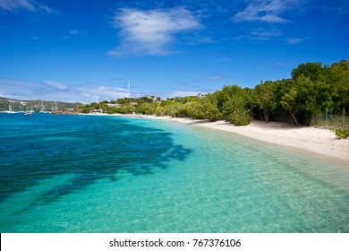 Weißer Sand und klares türkisfarbenes Wasser am Pigeon Beach in Antigua.