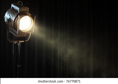 vintage theater spot light on black curtain with smoke
