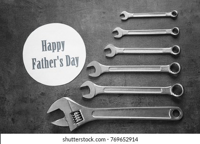 Karte mit Text Happy Father's Day und Ringmaulschlüssel auf grauem Hintergrund