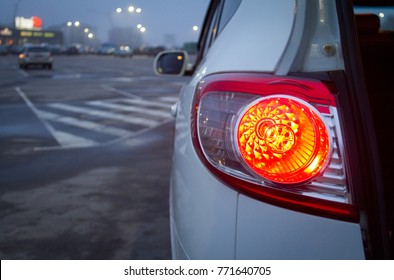 Bijeli Hyundai Santa FE na parkingu. Crvena semafora izgledaju sjajno na tom terencu noću